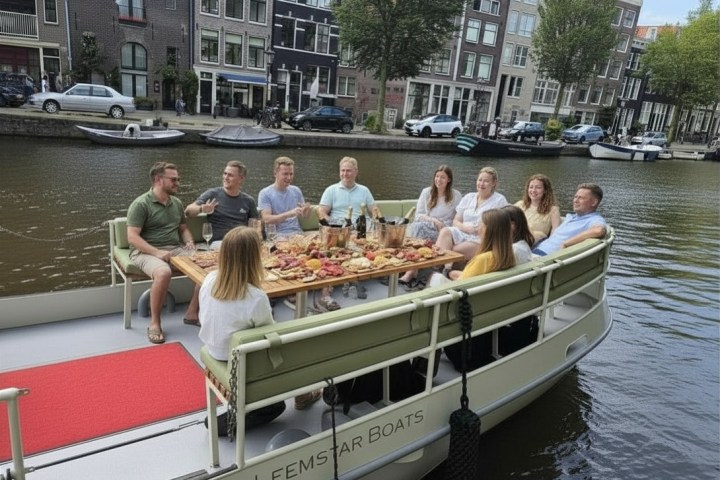 Group of people dining on a boat on a canal with buildings in the background.