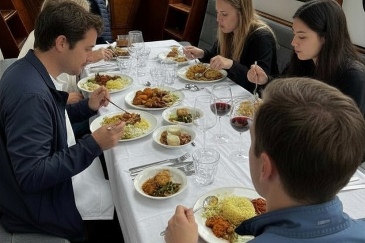 People dining on a boat with a table set for a meal.
