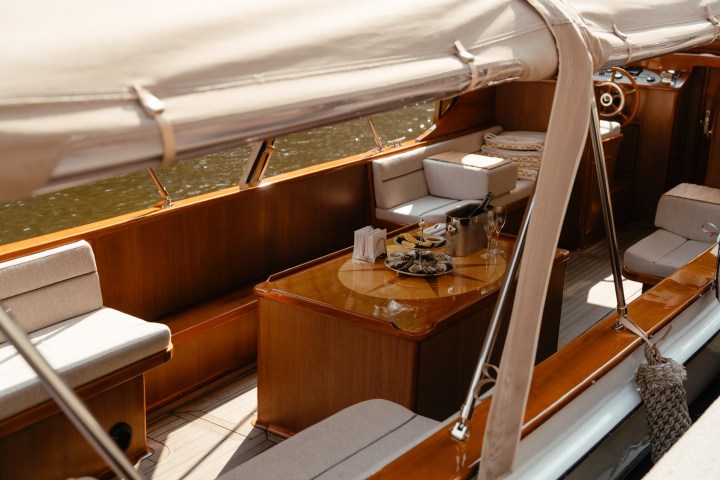 Interior of a wooden boat with a table set for dining.