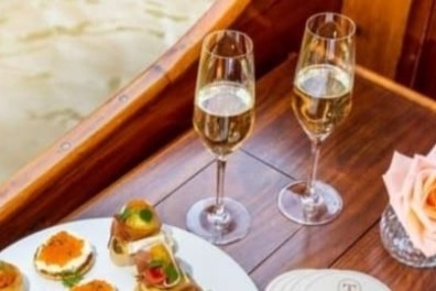 Plate of appetizers and two champagne glasses on a wooden table.