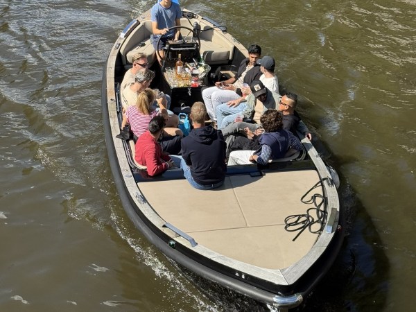 Group of people sitting on a boat in a river.