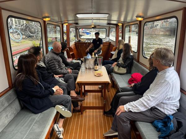 Group of people sitting inside a boat on a canal tour.