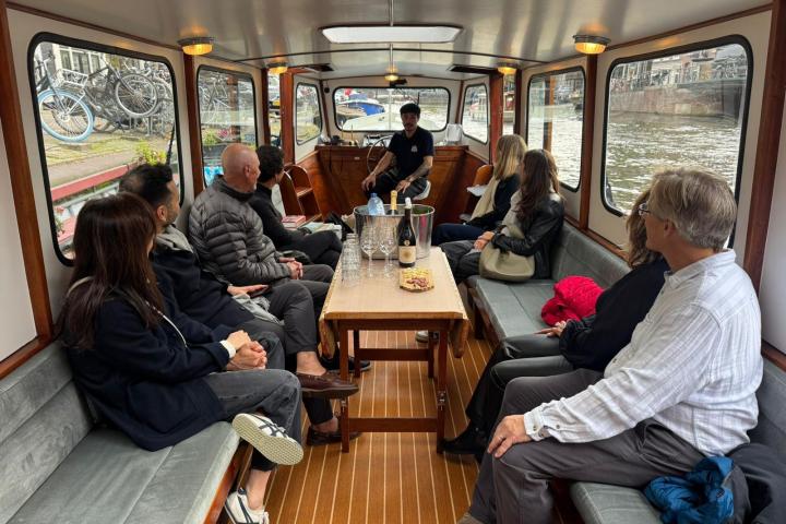 Group of people sitting inside a boat on a canal tour.